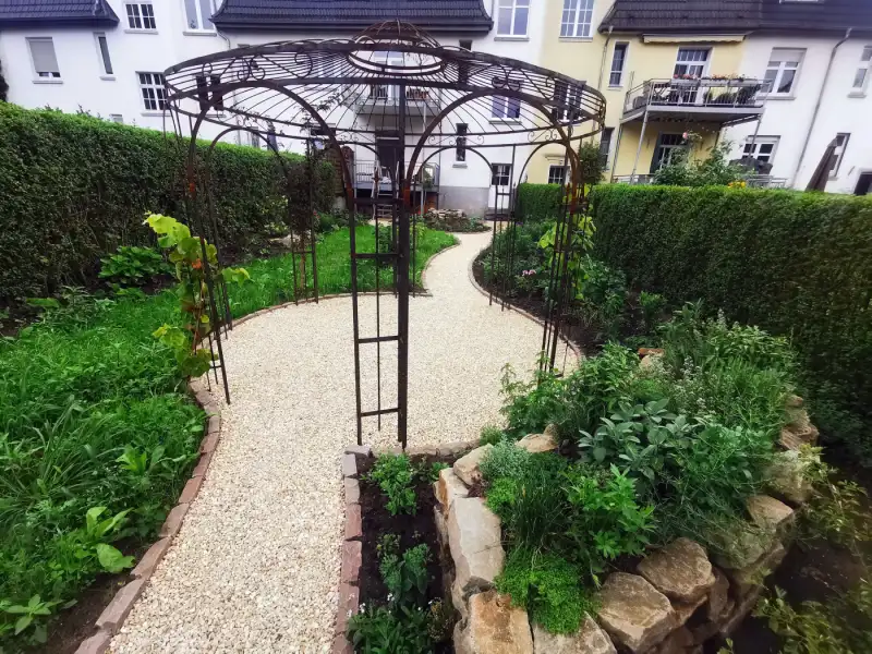 Pavillon im Sommer, die Beete sind eingewachsen