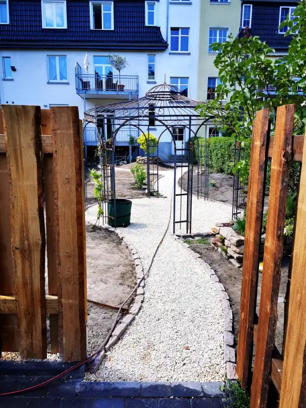 Durchgang mit Holztor zum hinteren Gartenteil