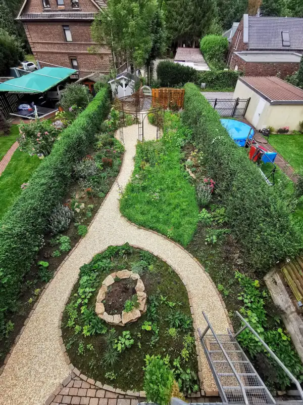 Hinterhofgarten in Herne mit Kieswegen und Natursteinbeeten